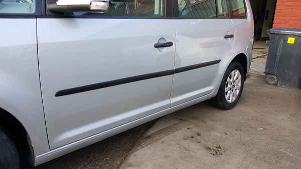 Silver car door with a flawless refinished panel